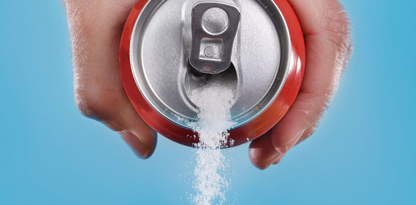 A soda can is spilling sugar