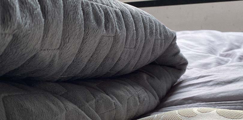 A grey, folded weighted blanket.